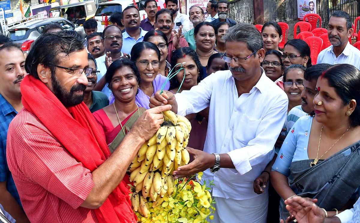 A farmer offeringt bananas to LDF candidate C. Ravindranath during his campaign at Manalur.
