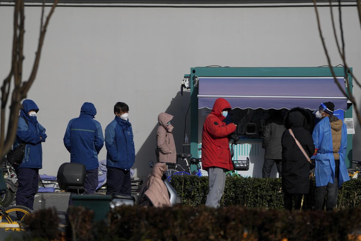 Residents stand in line for their routine COVID-19 tests in the freezing cold weather at a testing site in Beijing on November 29, 2022.