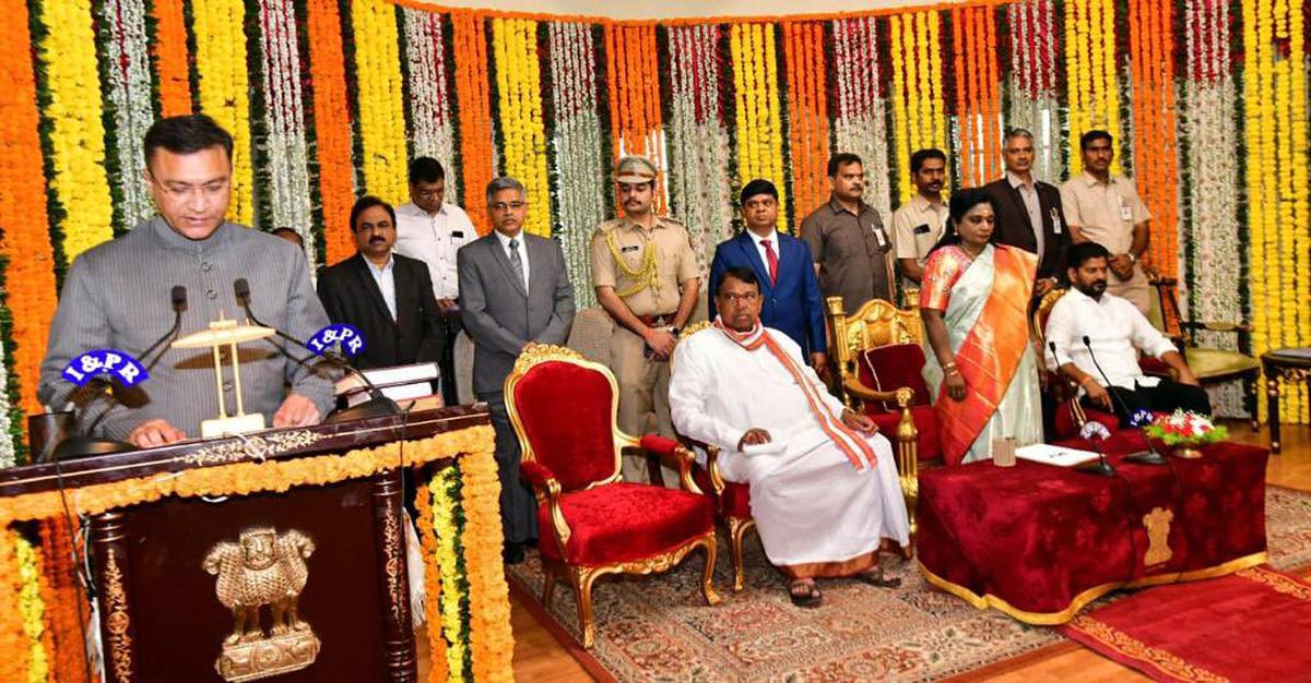 Telangana Governor Tamilisai Soundararajan administers the oath of office to Pro Tem Speaker of the State Legislative Assembly Akbaruddin Owaisi during the swearing-in ceremony at Raj Bhavan in Hyderabad on Saturday. Telangana Chief Minister Revanth Reddy and other dignitaries are also present.  