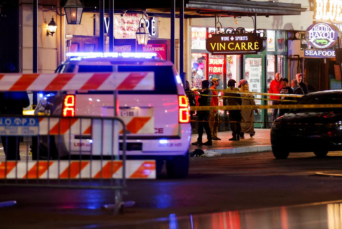 Law enforcement vehicles and people stand near the area near the scene where a vehicle drove into a crowd during New Year’s celebrations, in New Orleans, Louisiana, U.S., January 1, 2025. 