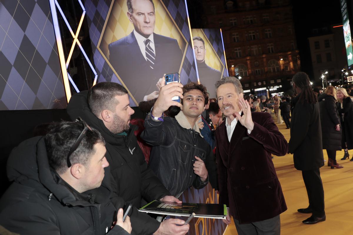 Bryan Cranston poses for a selfie with fans during the world premiere of ‘Argylle’