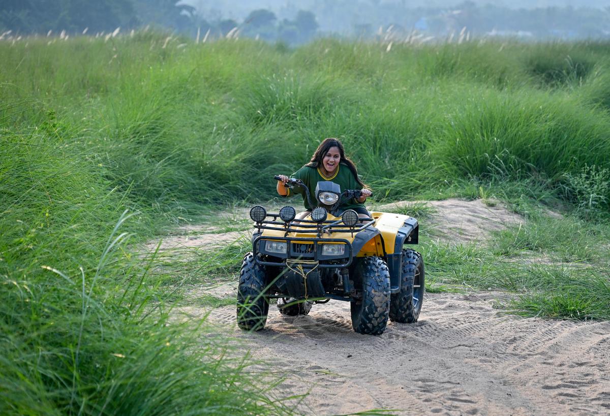 A visitor enjoying an ATV ride on the banks of river Nagavali at Anija in Rayagada, Odisha.