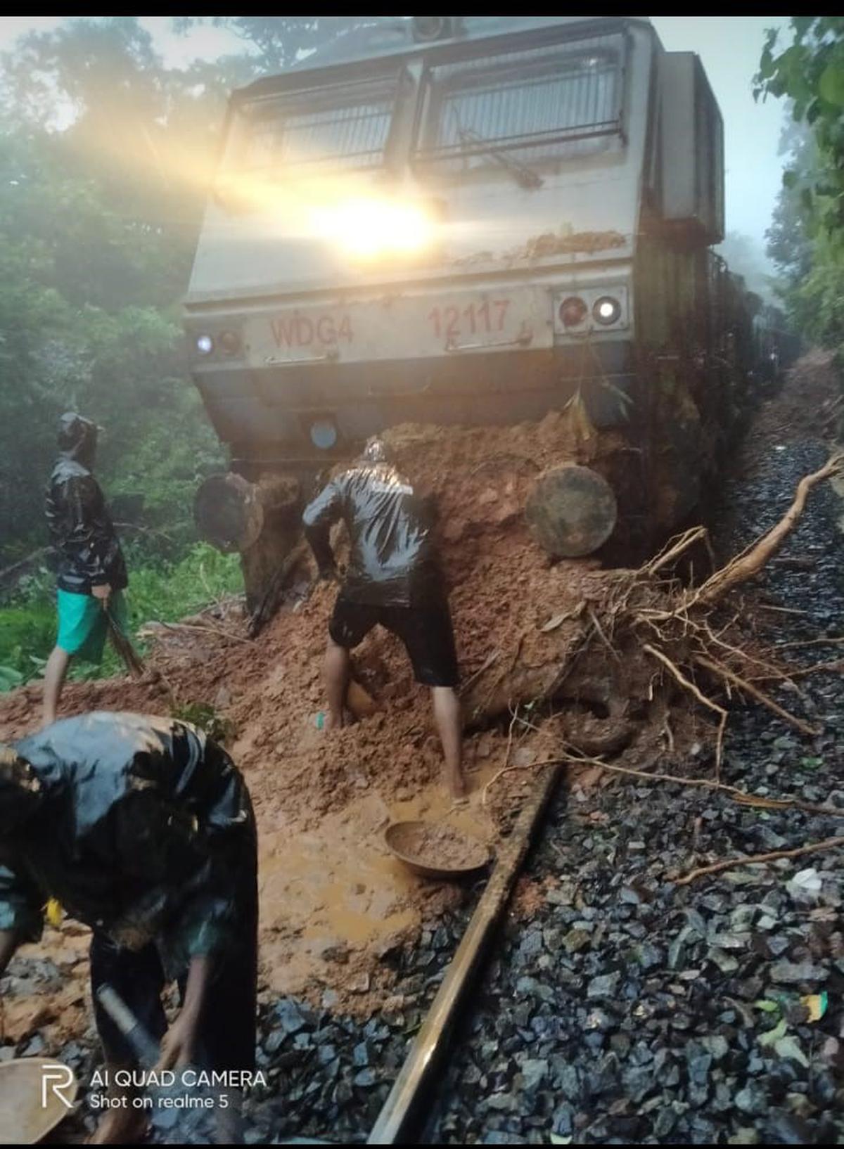 Railway workers clearing mud from the track following a landslide near Castle Rock in Uttara Kannada district of Karnataka, on July 26, 2023. 