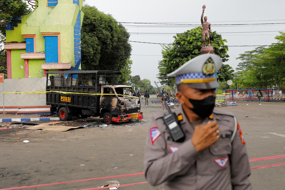 A police officer guards outside the stadium after a riot and stampede following soccer matches between Arema vs Persebaya at Kanjuruhan stadium in Malang, East Java province, Indonesia, on October 2, 2022. 