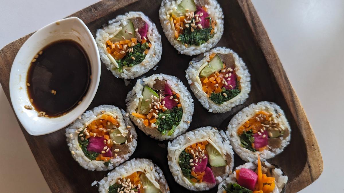 Gimbap with vegetables and cheese, served with a soy dipping sauce