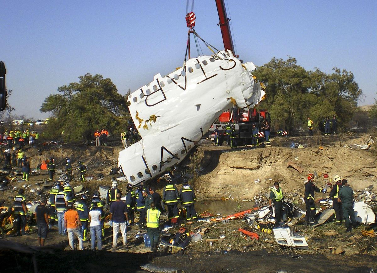 A part of the fuselage of the Spanair jet that crashed on take off at Madrid airport is lifted by a crane on Wednesday, Aug. 20, 2008. A part of the fuselage of the Spanair jet that crashed on take off at Madrid airport is lifted by a crane on Wednesday, Aug. 20, 2008.