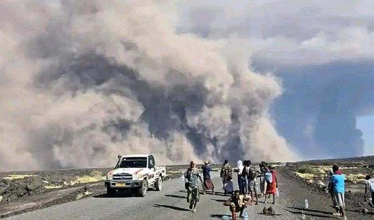 In this photo released by the Afar Government Communication Bureau, people watch ash billow from an eruption of the long-dormant Hayli Gubbi Volcano in Ethiopia's Afar region on November 23, 2025. 