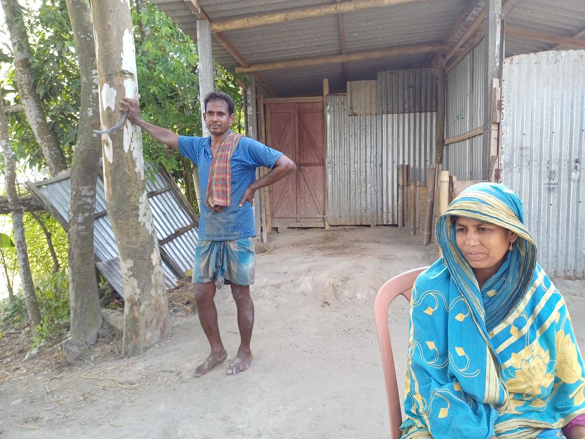 Asma Bibi with her husband Shahjahan Ali outside their house in Madhya Masaldanga. 