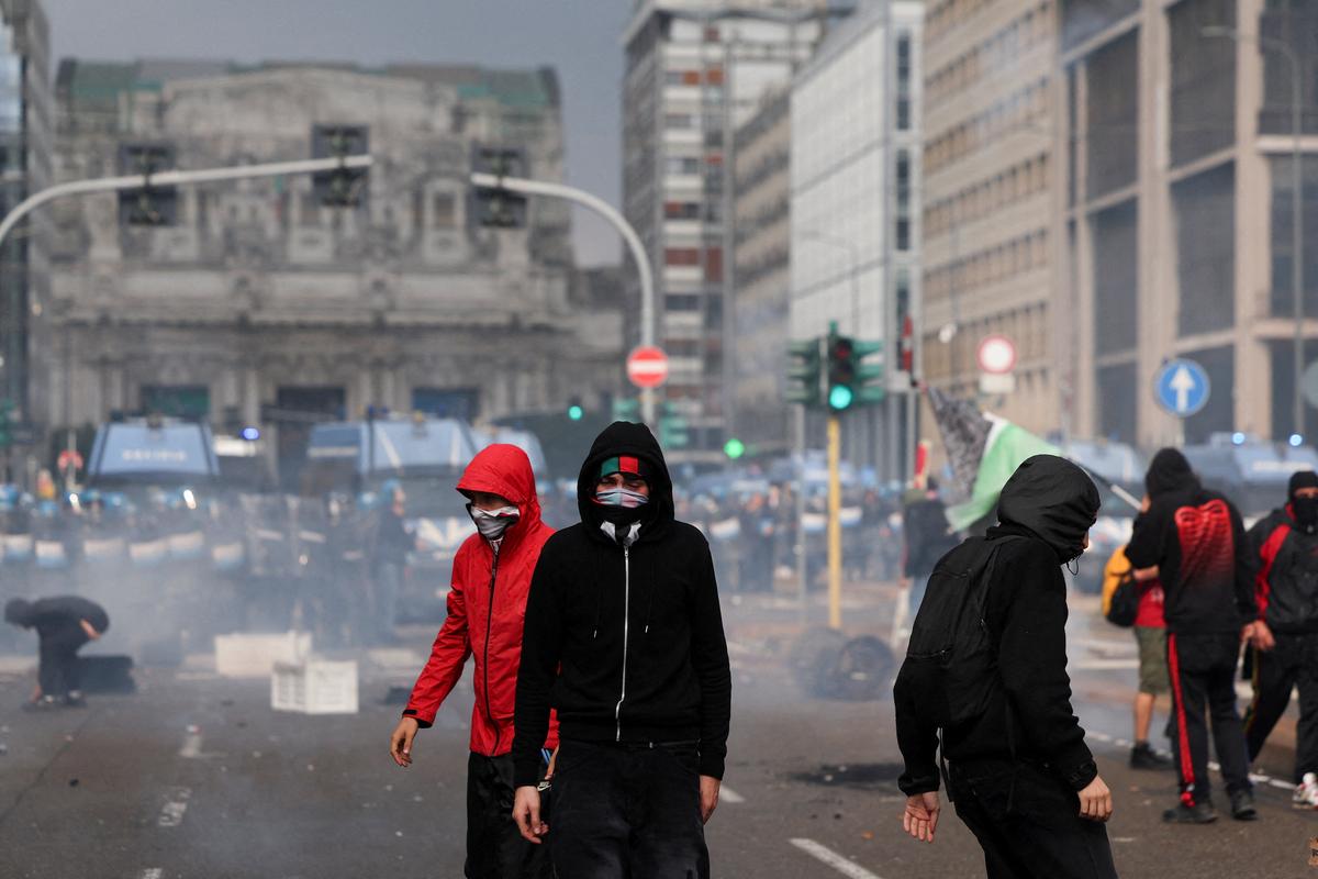 Protesters with their faces covered walk outside Milano Centrale railway station, as they clash with members of the law enforcement during a demonstration that is part of a nationwide “Let’s Block Everything” protest in solidarity with Gaza, with activists also calling for a halt to arms shipments to Israel, in Milan, Italy September 22, 2025. 