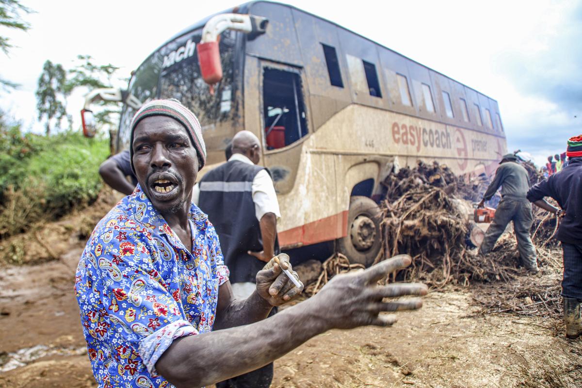 People try to clear a bus that was washed away after the dam burst.