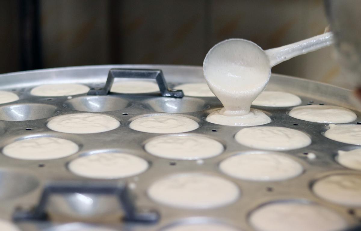 Idli batter being poured into the moulds at the food production unit