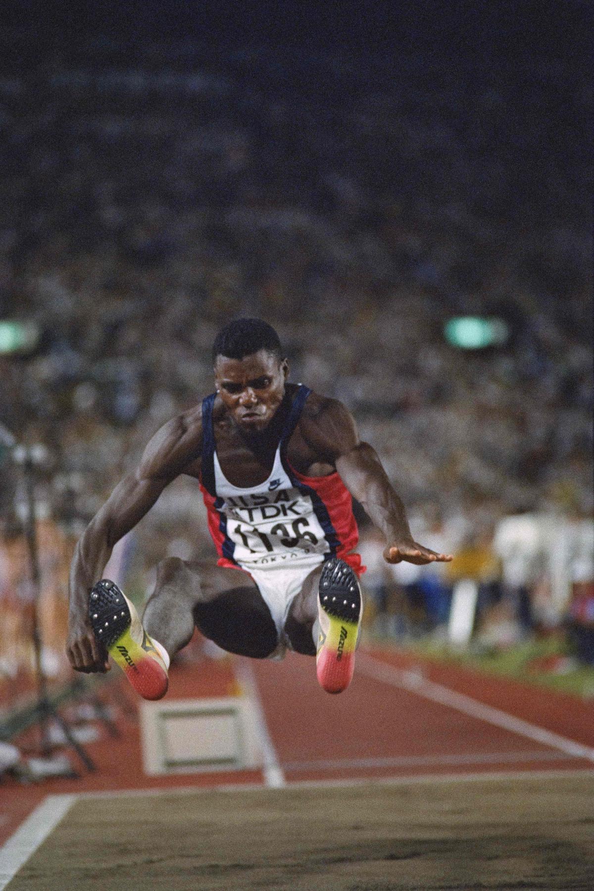 (FILES) US's Carl Lewis jumps 8.56 meters in the qualifing round of the long jump event at the 3rd World Athletics Champioships in Tokyo on August 29, 1991. With the 2025 World Championships in Tokyo, a suspended memory resurfaces, that of the mythical long jump competition of August 30, 1991. An epic duel between Carl Lewis, the invincible finally beaten, and Mike Powell, the outsider who flew to 8.95m. A record set in stone. (Photo by Toshifumi KITAMURA / AFP) (FILES) US's Carl Lewis jumps 8.56 meters in the qualifing round of the long jump event at the 3rd World Athletics Champioships in Tokyo on August 29, 1991. With the 2025 World Championships in Tokyo, a suspended memory resurfaces, that of the mythical long jump competition of August 30, 1991. An epic duel between Carl Lewis, the invincible finally beaten, and Mike Powell, the outsider who flew to 8.95m. A record set in stone. (Photo by Toshifumi KITAMURA / AFP)