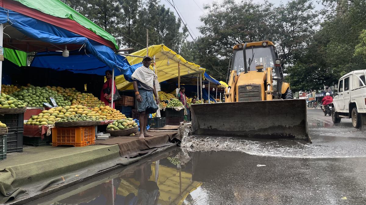 An earthmover clearing stagnated rain water on Jayamahal Palace Road in Bengaluru on Tuesday.