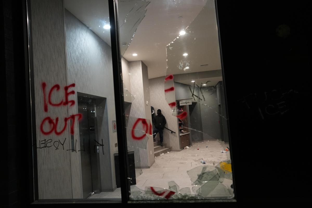 A smashed window is seen at a hotel during a noise demonstration protest in response to federal immigration enforcement operations in the city ON Sunday, Jan. 25, 2026, in Minneapolis.