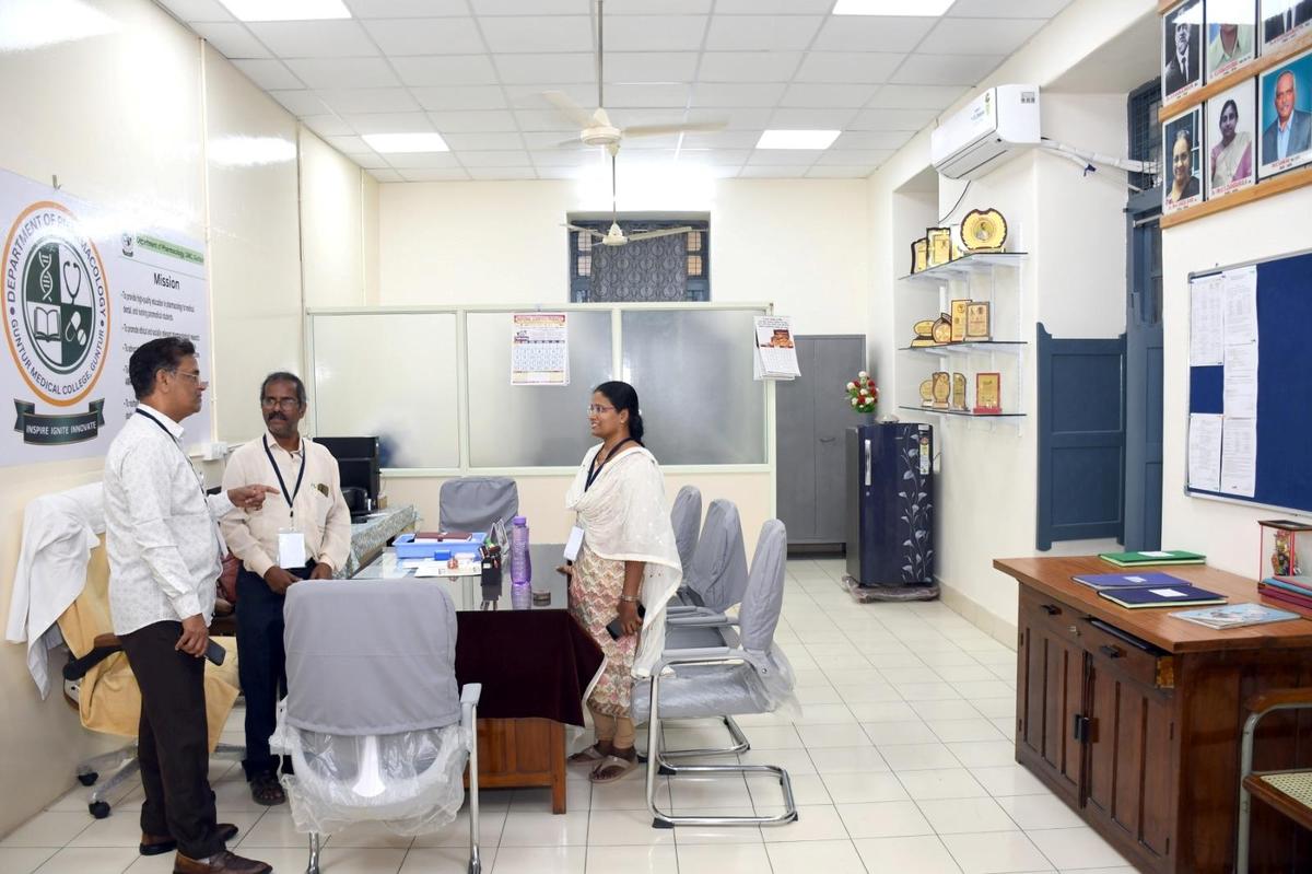 Diretor do Guntur Medical College NV Sundarachary interagindo com o corpo docente em uma sala reformada de um colega do Colégio em Guntur. 
