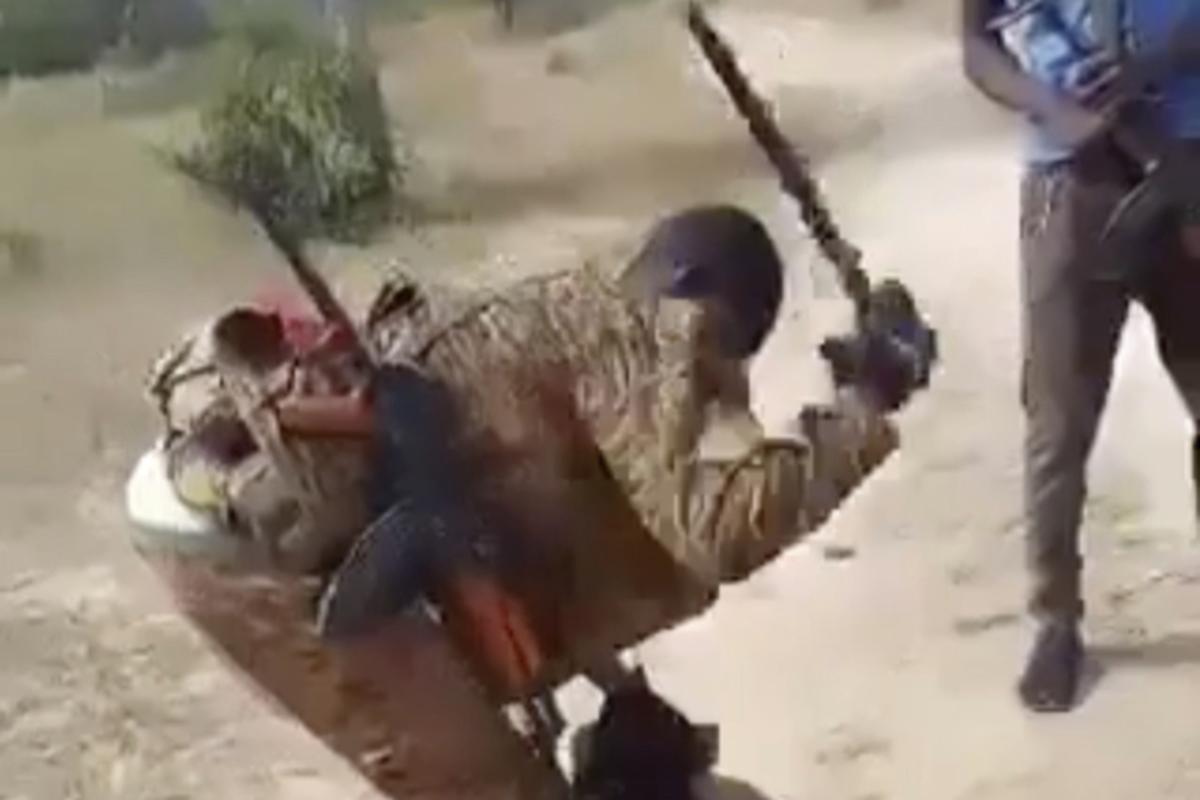 In this image from video posted on a Wagner Group-affiliated Telegram channel in July 2024, a man in a Burkina Faso armed forces uniform uses a machete to cut up a dead body lying on the ground. In this image from video posted on a Wagner Group-affiliated Telegram channel in July 2024, a man in a Burkina Faso armed forces uniform uses a machete to cut up a dead body lying on the ground.