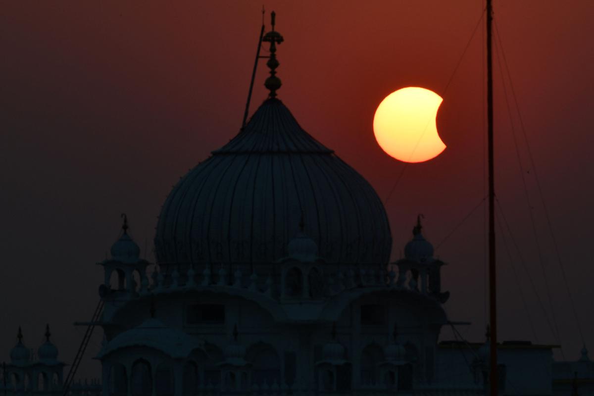 The moon (R) partially obscures the sun during a partial solar eclipse visible from Patna on October 25, 2022. 