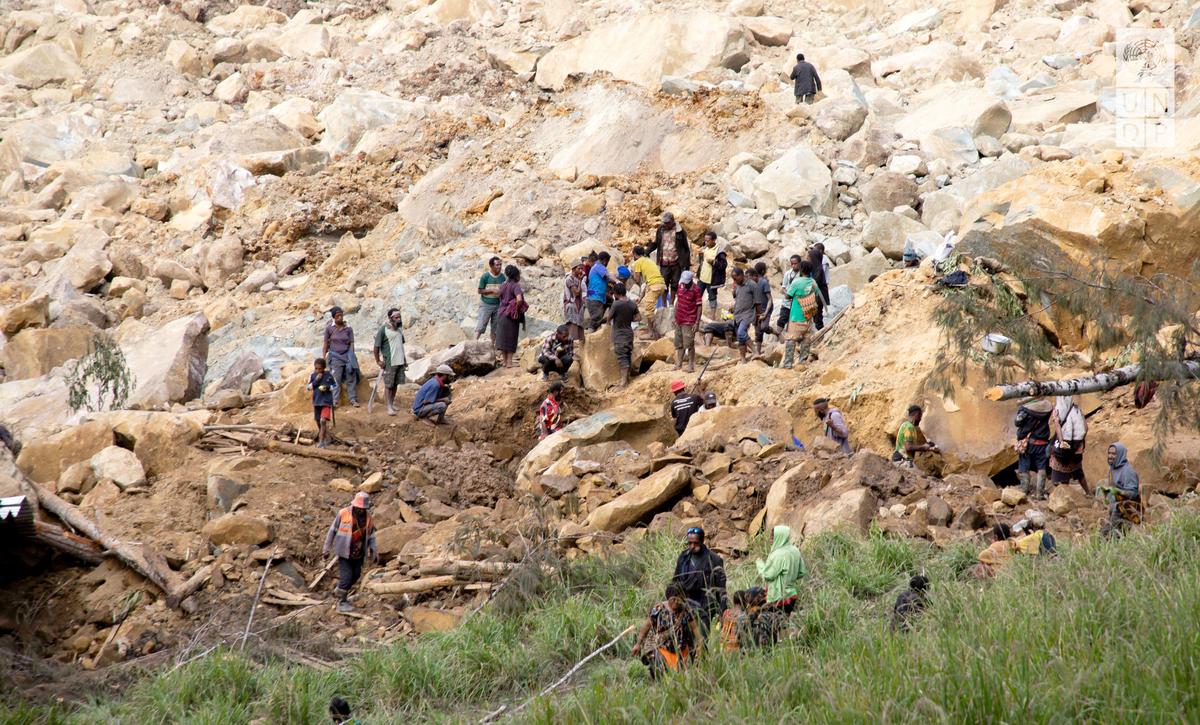 People clear an area at the site of a landslide in Yambali village, Enga Province, Papua New Guinea on May 27, 2024. 