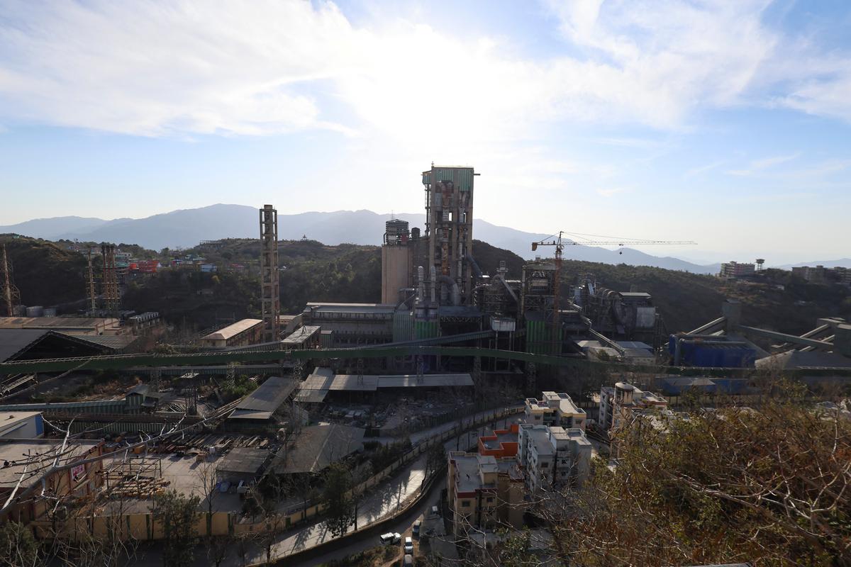 A view of the Ambuja Cements Limited plant owned by Adani Group is seen from a nearby village in Darlaghat, Solan district, Himachal Pradesh