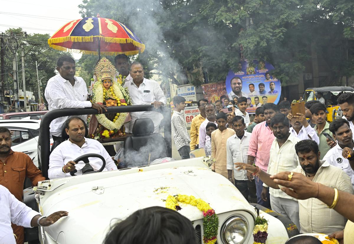 Devotees take out procession of Goddess Mahankali at Chappal Bazzar during Bonalu celebrations in Hyderabad on Sunday.