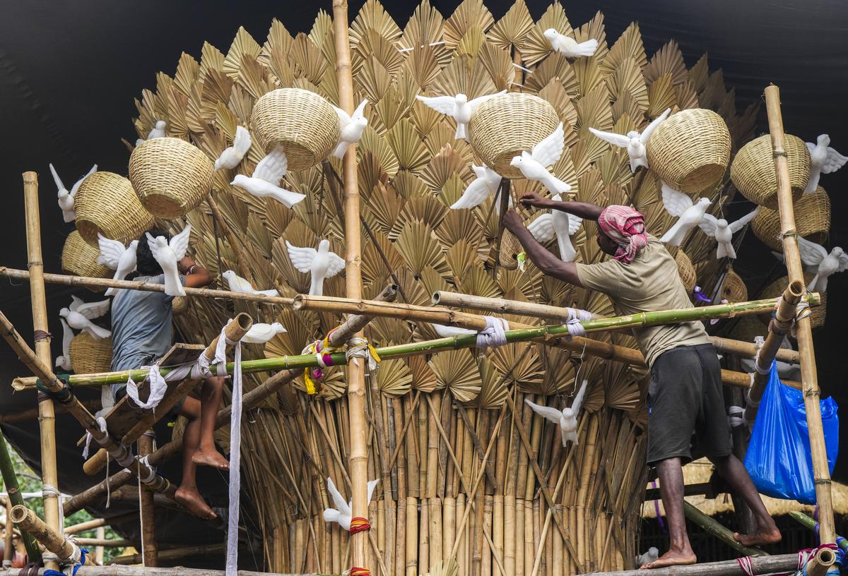 Workers deck up a pandal themed Free the birds from cages 