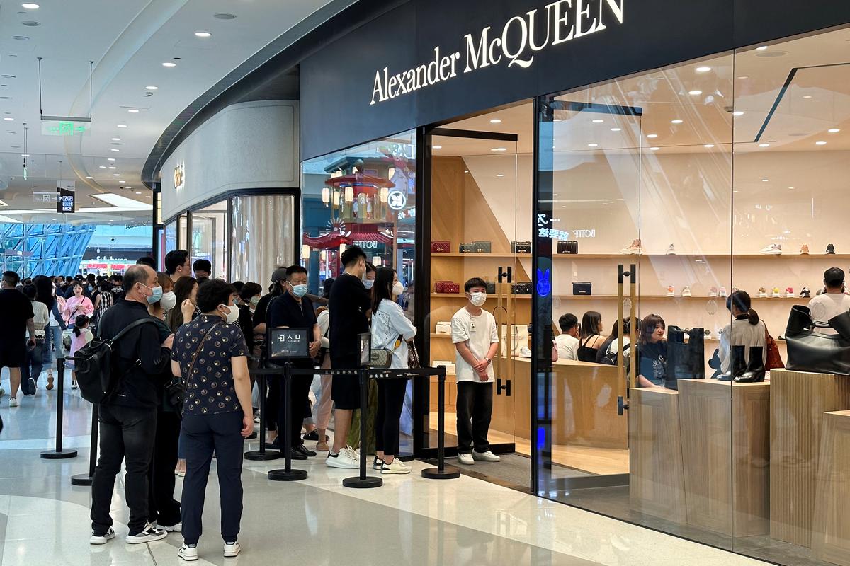 People wait in line to enter an Alexander McQueen store at a shopping complex in Sanya, Hainan province, China.