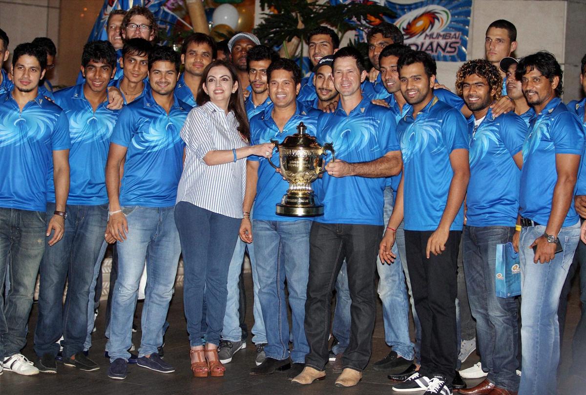 Mumbai Indians team owner Nita Ambani poses for a group photo with Sachin Tendulkar, Ricky Ponting, Rohit Sharma and other players during a bash thrown by her to celebrate the team’s victory in IPL-6 finals, in Mumbai on May 28, 2013