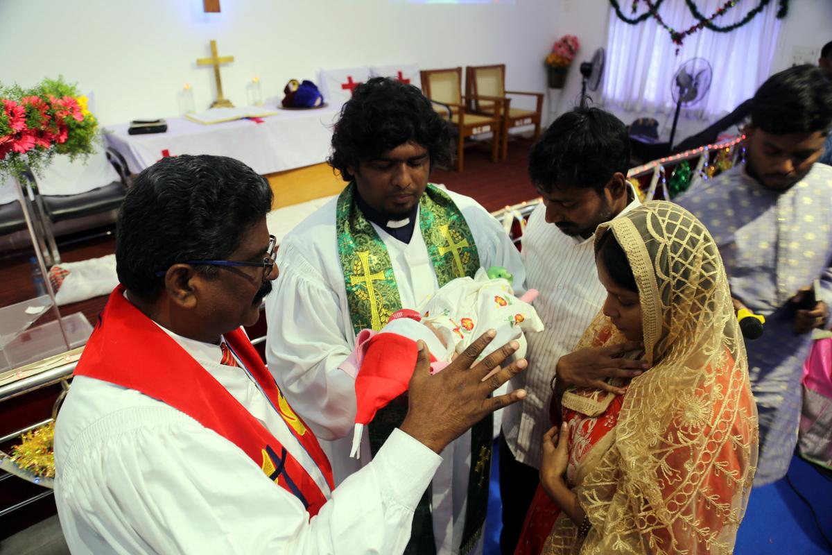 A couple with an infant taking blessings at Methodist Church on Christmas in Sangareddy on Thursday.