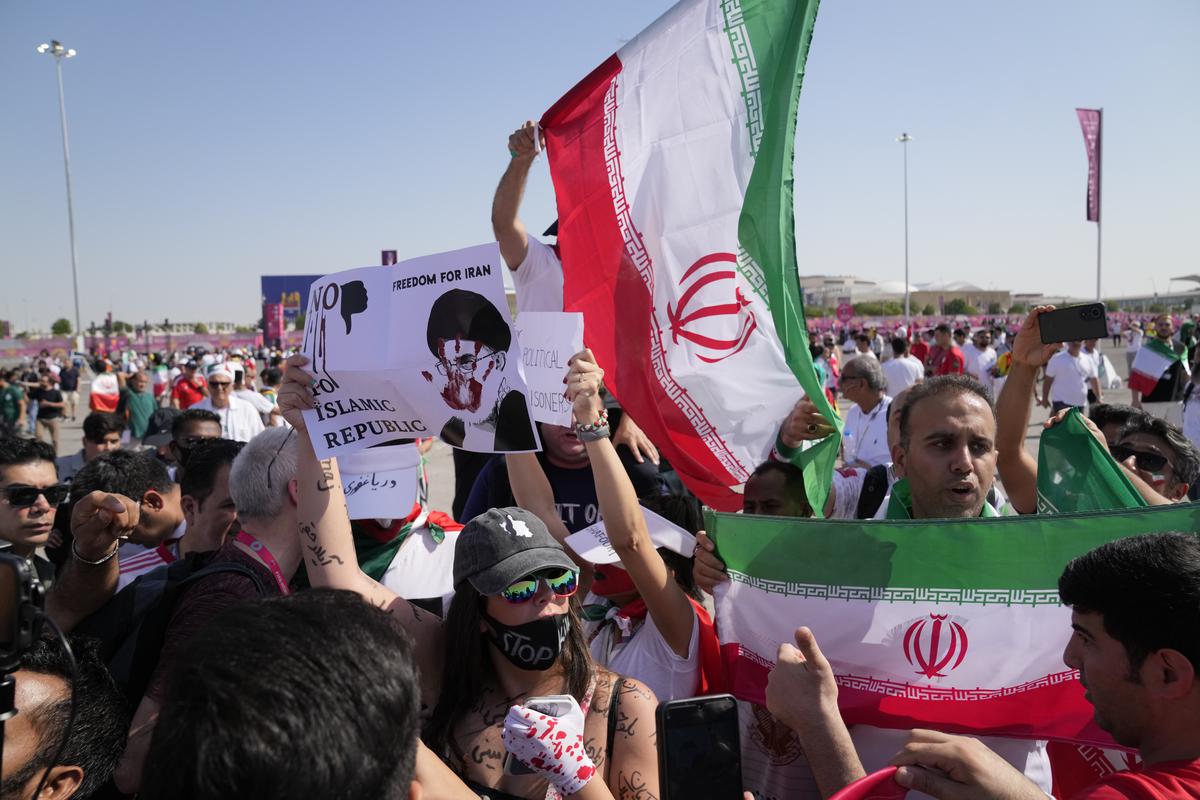 Supporters wave Iranian flags and a woman holds up a sign reading “Freedom for Iran, No to Islamic Republic”, ahead of the World Cup group B match between Wales and Iran at the Ahmad Bin Ali Stadium in Al Rayyan in Qatar on November 25, 2022.