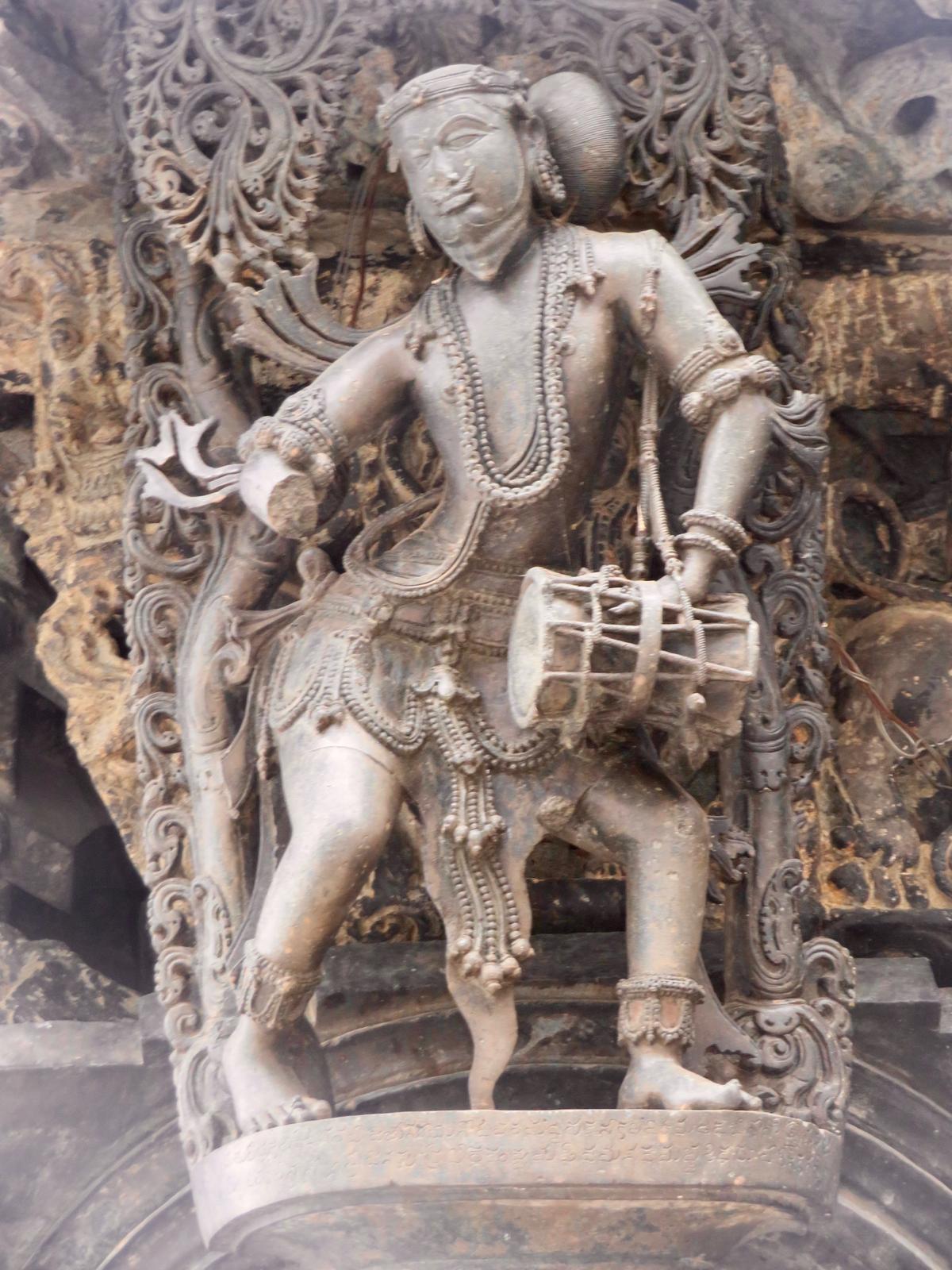 बेलूर के चेन्नाकेशव मंदिर में ड्रम के साथ एक संगीतकार की मूर्ति। बेलूर के चेन्नाकेशव मंदिर में ड्रम के साथ एक संगीतकार की मूर्ति।