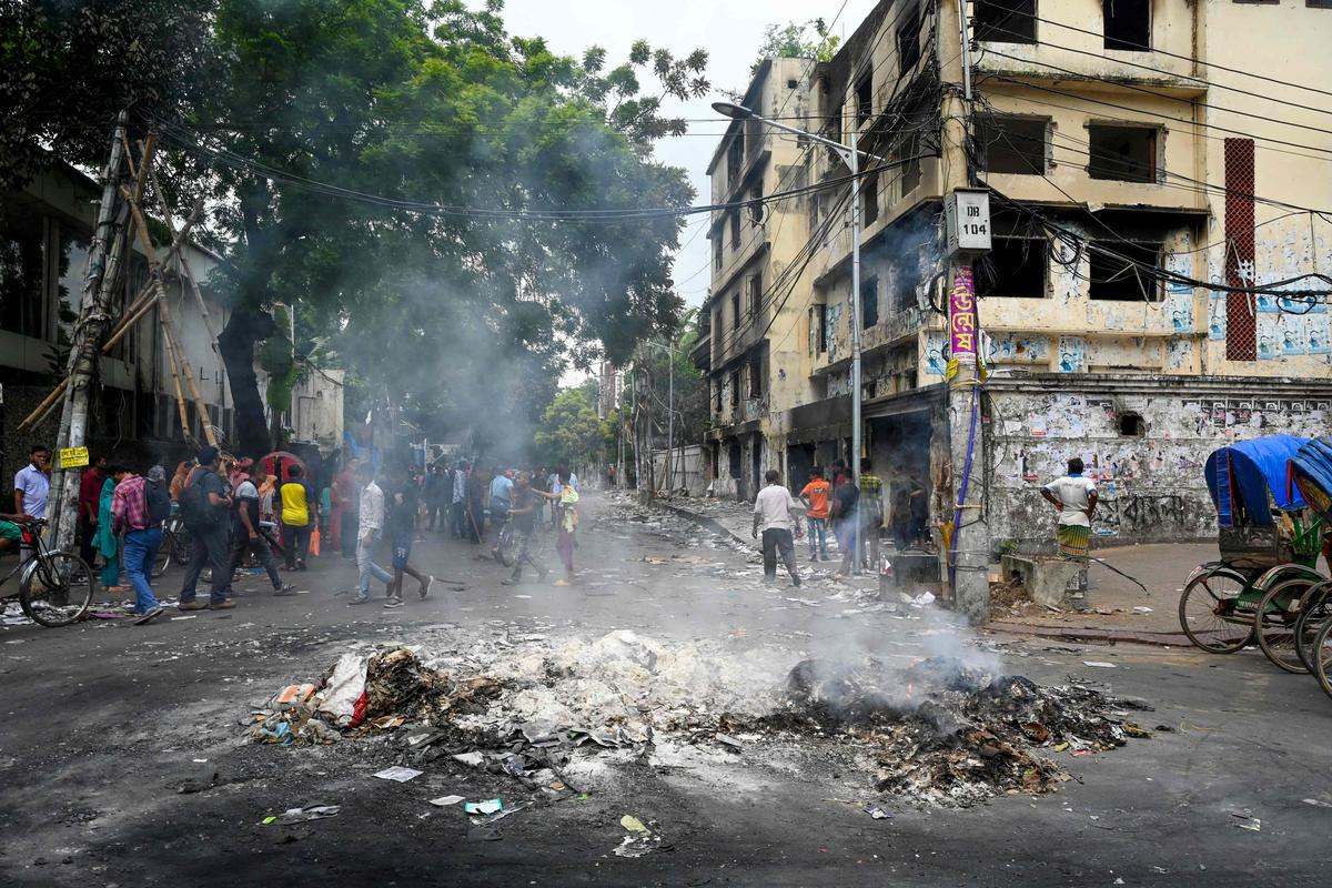 Smoke billows near a burnt Awami League party office as anti-government protestors set fire in Dhaka on August 6, 2024, after Prime Minister Sheikh Hasina fled the country.  Smoke billows near a burnt Awami League party office as anti-government protestors set fire in Dhaka on August 6, 2024, after Prime Minister Sheikh Hasina fled the country.
