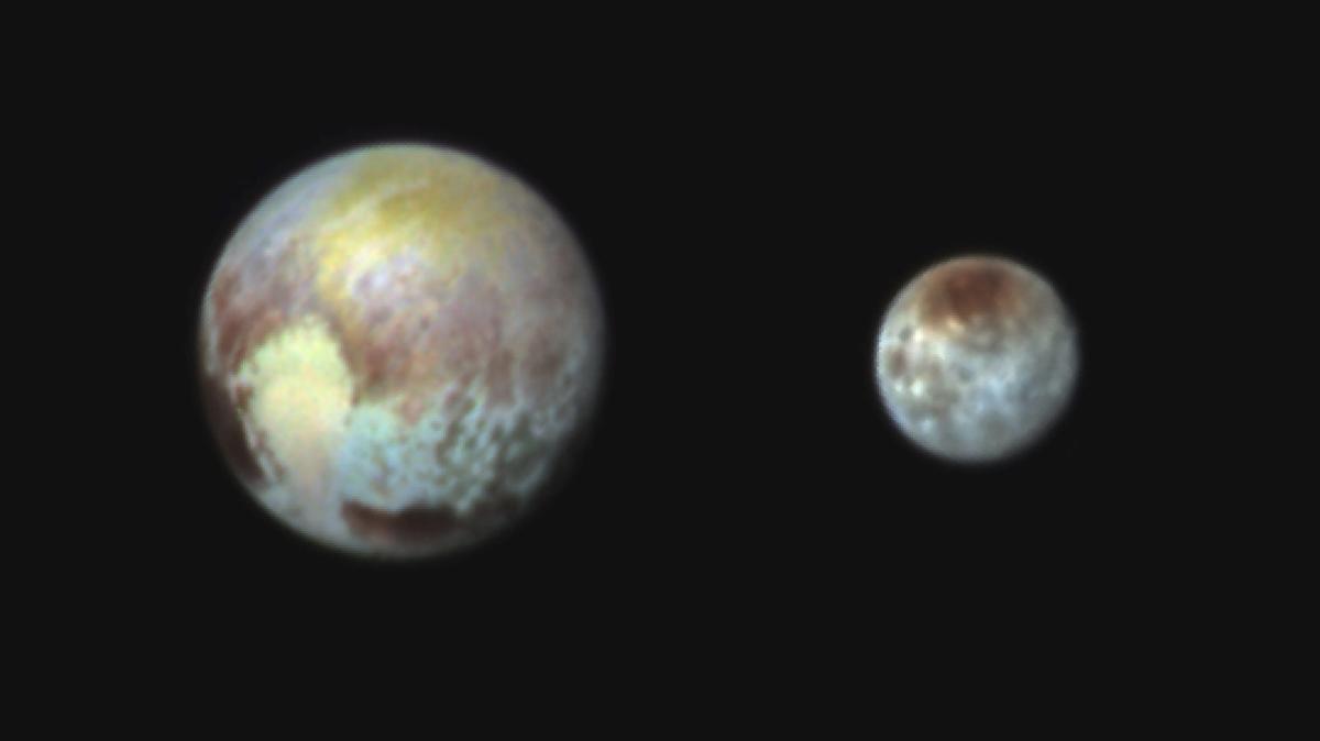 A handout combination image released by NASA and sent to Earth on July 13, 2015, shows Pluto (left) and its moon Charon, presented in false colours to make differences in surface material and features easy to see. 