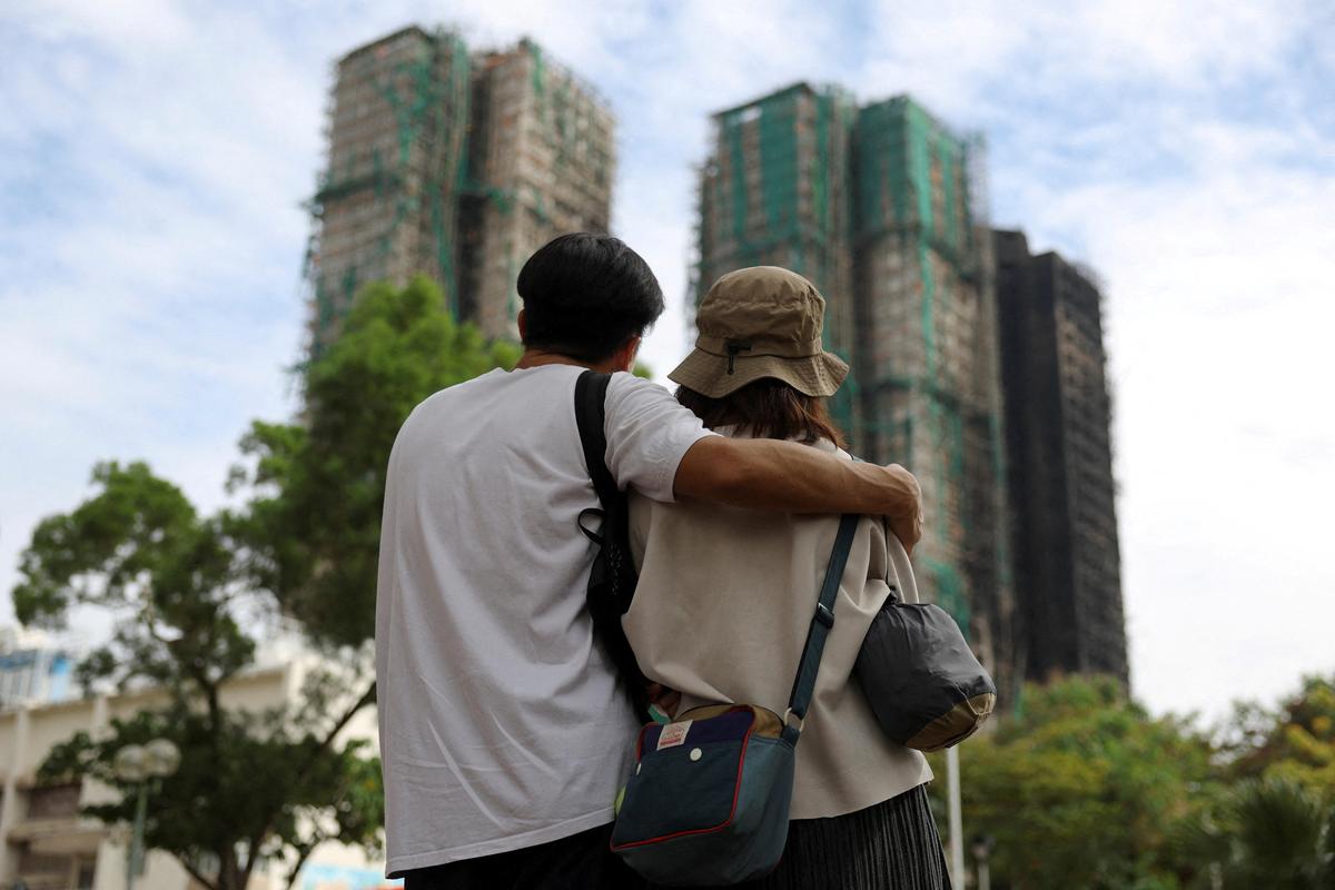 People look on near the Wang Fuk Court housing complex following the deadly fire on Wednesday, in Tai Po, Hong Kong, China December 1, 2025. 