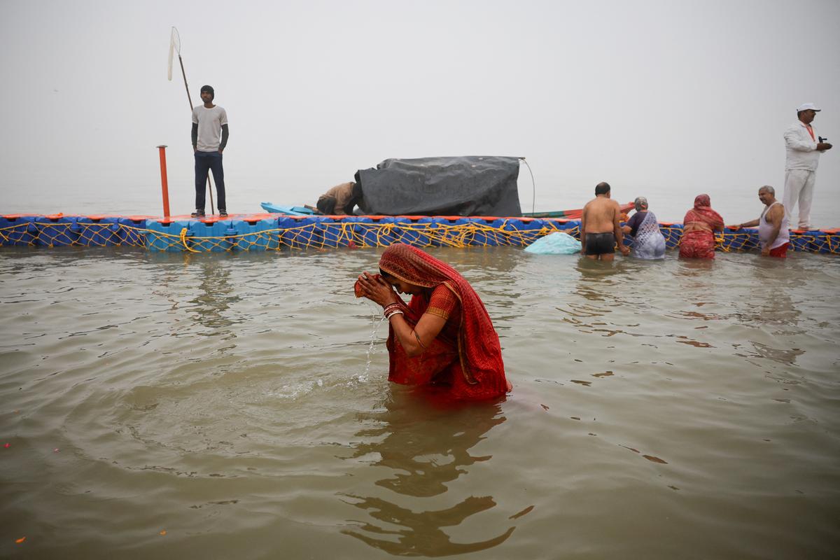 A devotee takes a holy dip at Sangam, the confluence of the Ganges, Yamuna and Saraswati rivers, during the “Maha Kumbh Mela”, or the Great Pitcher Festival, in Prayagraj, India, January 13, 2025. 