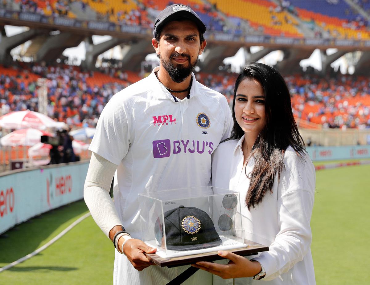 Proud moment: Ishant, with his wife, holding his 100th Test cap.