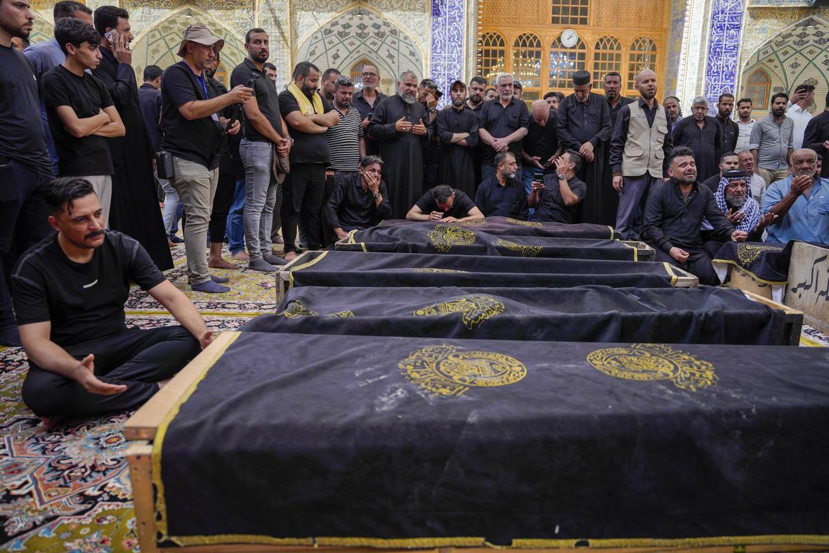 Mourners attend the funeral of victims who died in a fire at a shopping center in Kut, at the shrine of Imam Ali in Najaf, Iraq, on July 17, 2025.