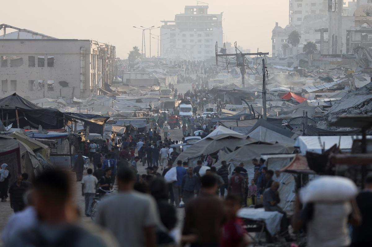 Palestinians gather to collect aid supplies after trucks loaded with aid entered from Israel through central Gaza, in Gaza City July 22, 2025.
