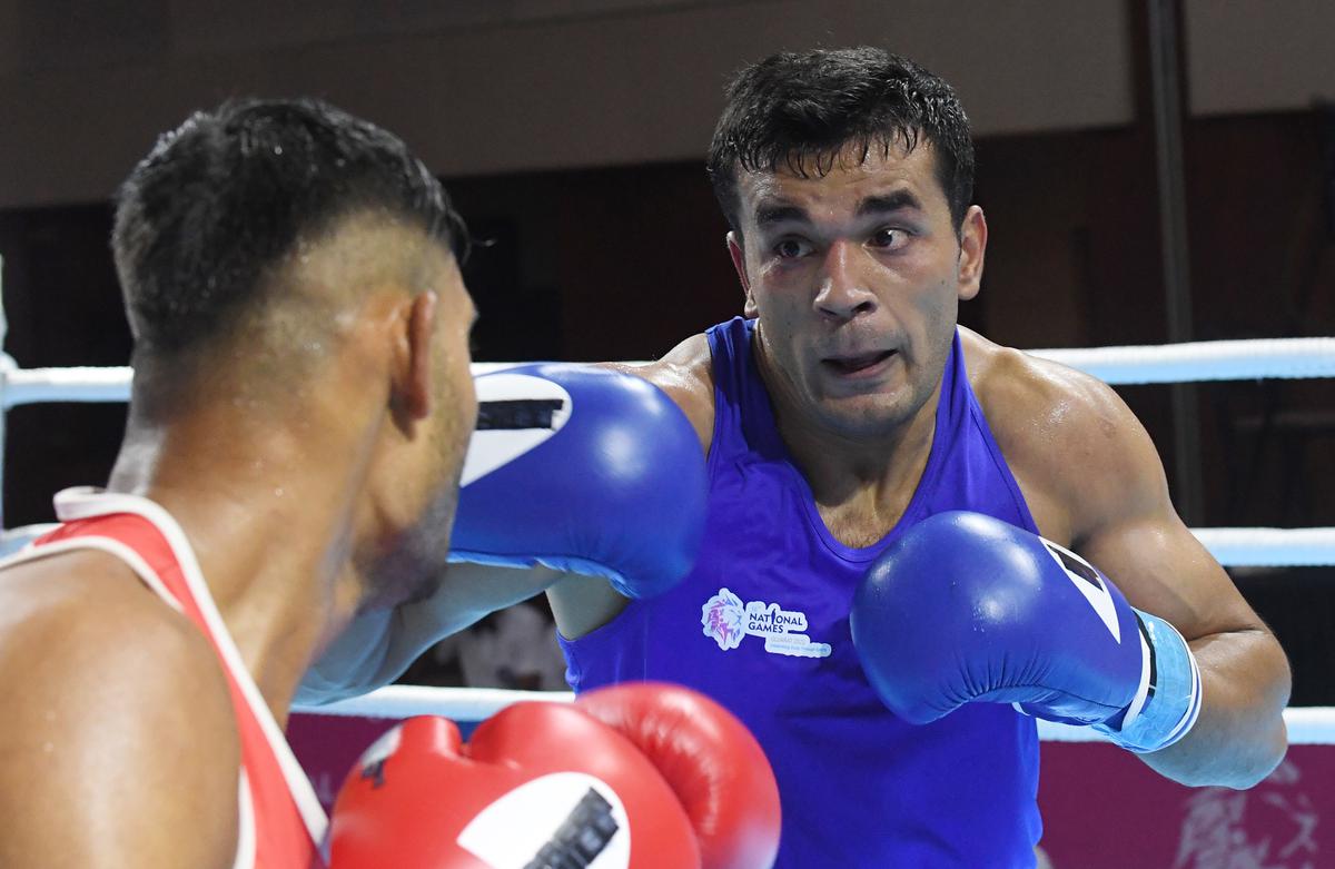 Sachin Kumar of SSCB (Blue) against Sejad Aslam Bhai Lilghar in the Light Heavy weight category of Mens Boxing at Gandhinagar, during the 36th National Games in Gujarat. 