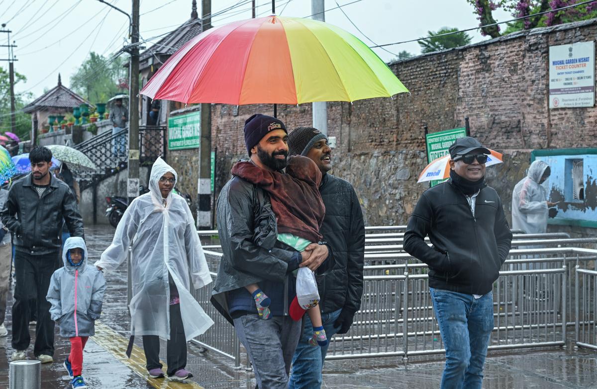 Visitors outside the Mughal Garden during rainfall in Srinagar. Kashmir has experienced a diverse weather condition as some areas in Kashmir’s high rivers received fresh snow while the rain lashed out at other parts.