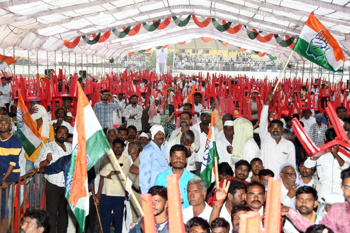 People using chairs to protect themselves from the rain while waiting for Congress MP Rahul Gandhi at a public meeting in Jewargi, Kalaburagi district, on April 28, 2023. 
