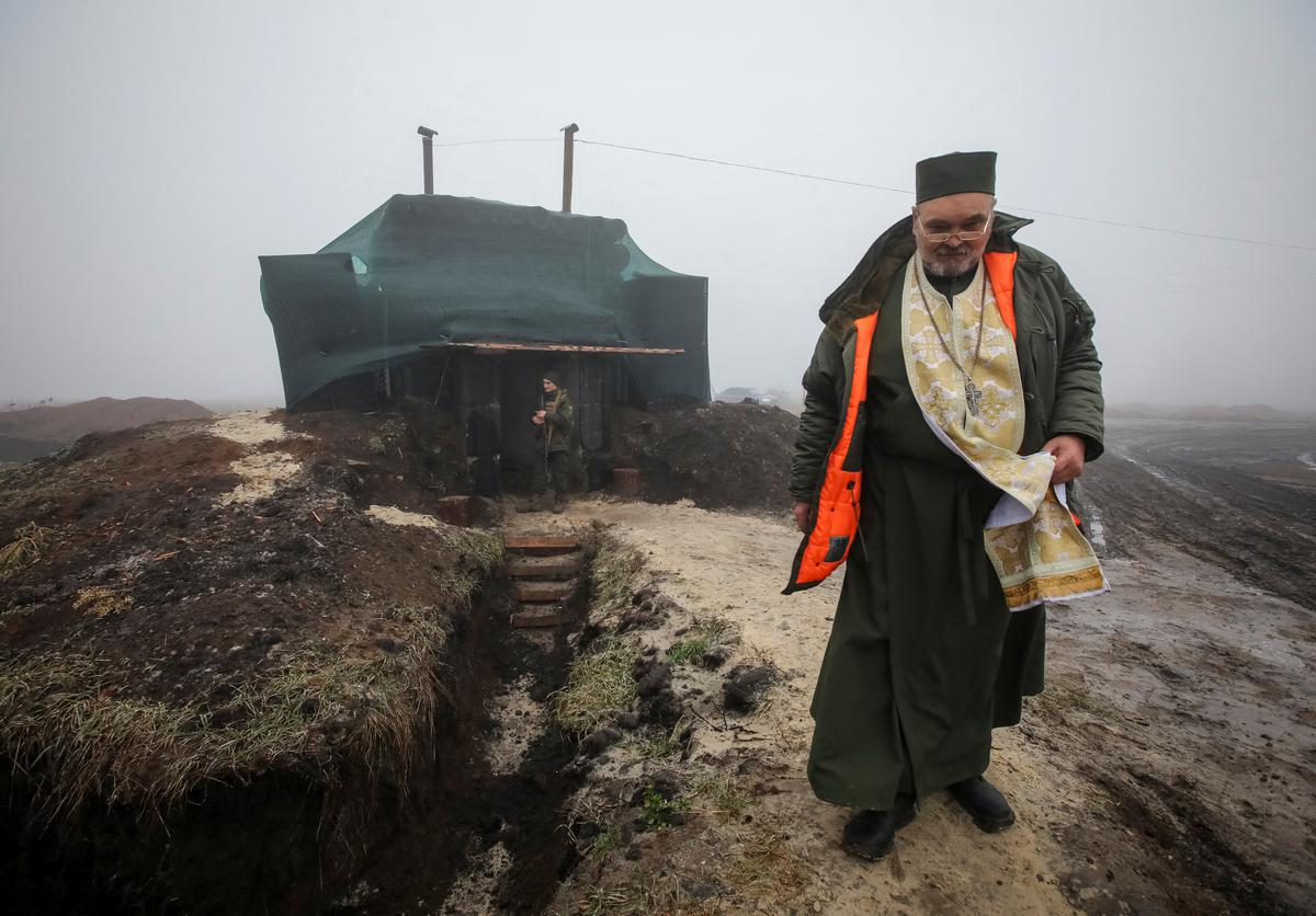 A priest Oleksandr of Orthodox Church of Ukraine conducts the Christmas service at a positions of servicemen of the Ukrainian National Guard, amid Russia’s attack on Ukraine, in Kharkiv region of Ukraine on December 24, 2022. 