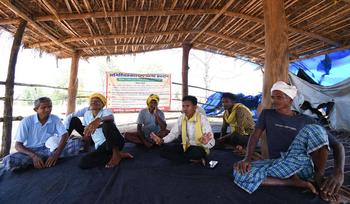 The sit-in protest site at the entrance to Hariharpur village, where the Hasdeo Arand Bachao Sangharsh Samiti has gathered every day since March 2, 2022. In white shirt, Muneshwar Singh Porte, a member of Samiti and resident of Fattepur village.