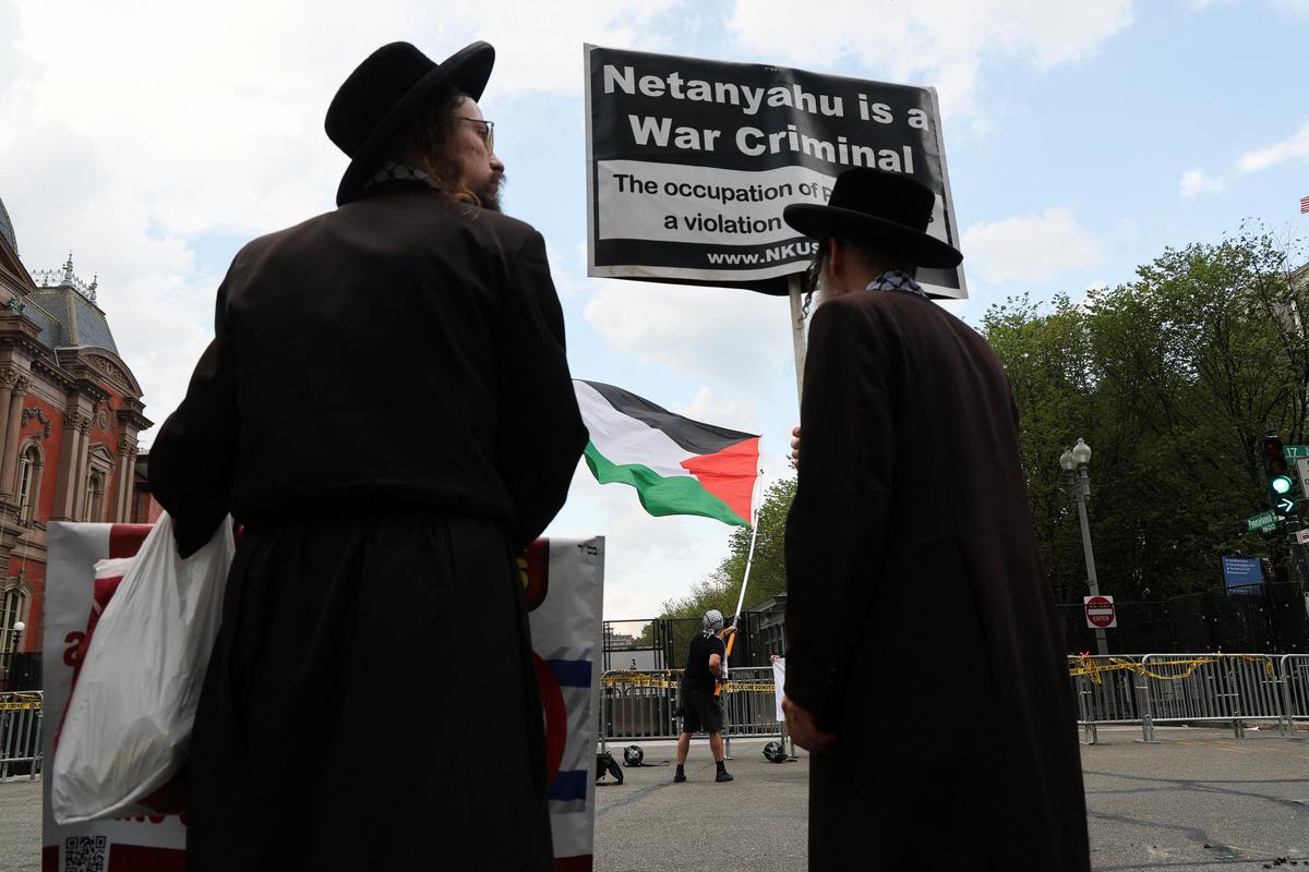 A demonstrator waves a Palestinian flag, while a member of the Neturei Karta, a fringe Jewish group that opposes the state of Israel, holds a sign, at a pro-Palestinian protest, during Israeli Prime Minister Benjamin Netanyahu’s visit to Washington, near the White House in Washington, D.C., U.S., July 8, 2025. 