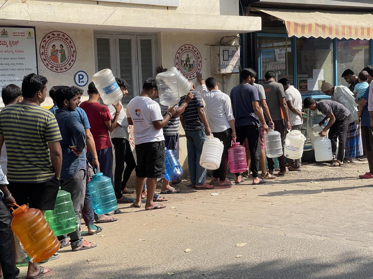 People stand in front of a water ATM at Rajarajeshwari Nagar, Bengaluru.