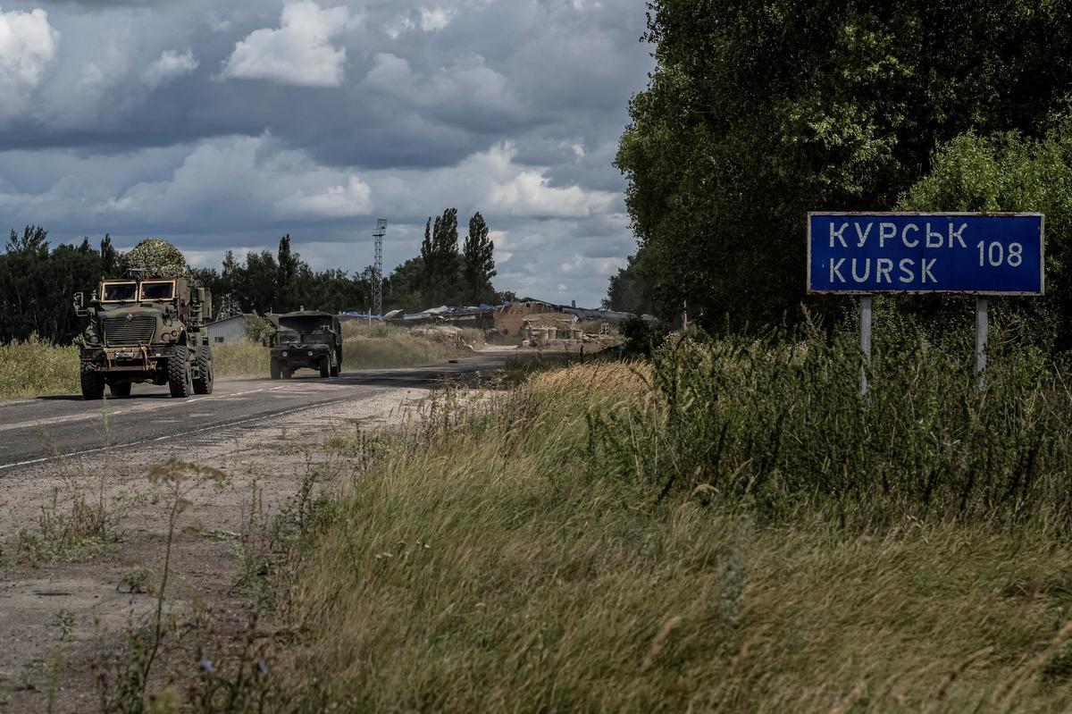 Ukrainian servicemen ride military vehicles from a crossing point at the border with Russia, amid Russia’s attack on Ukraine, in Sumy region.