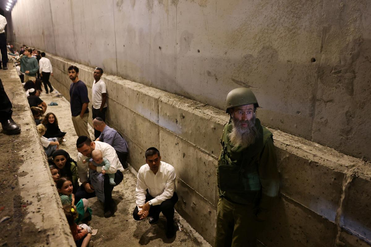 People take shelter during an air raid siren, amid cross-border hostilities between Hezbollah and Israel in central Israel on October 1, 2024. 