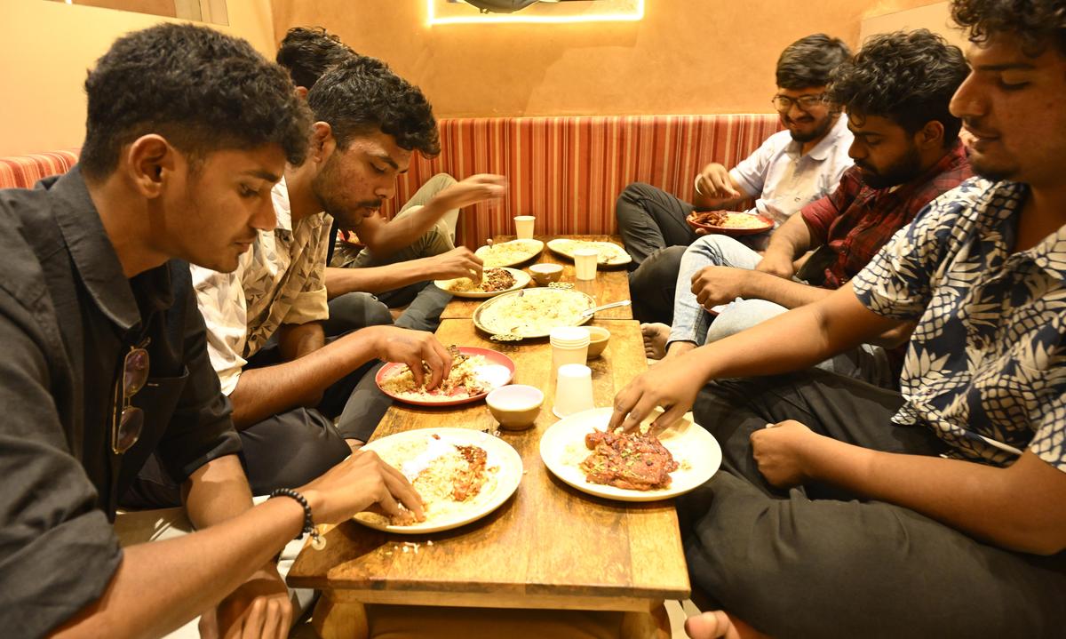 Posti a sedere sul pavimento in stile arabo con moquette e cuscini e momento dell'iftar in Street Arabiya a Ganapathy