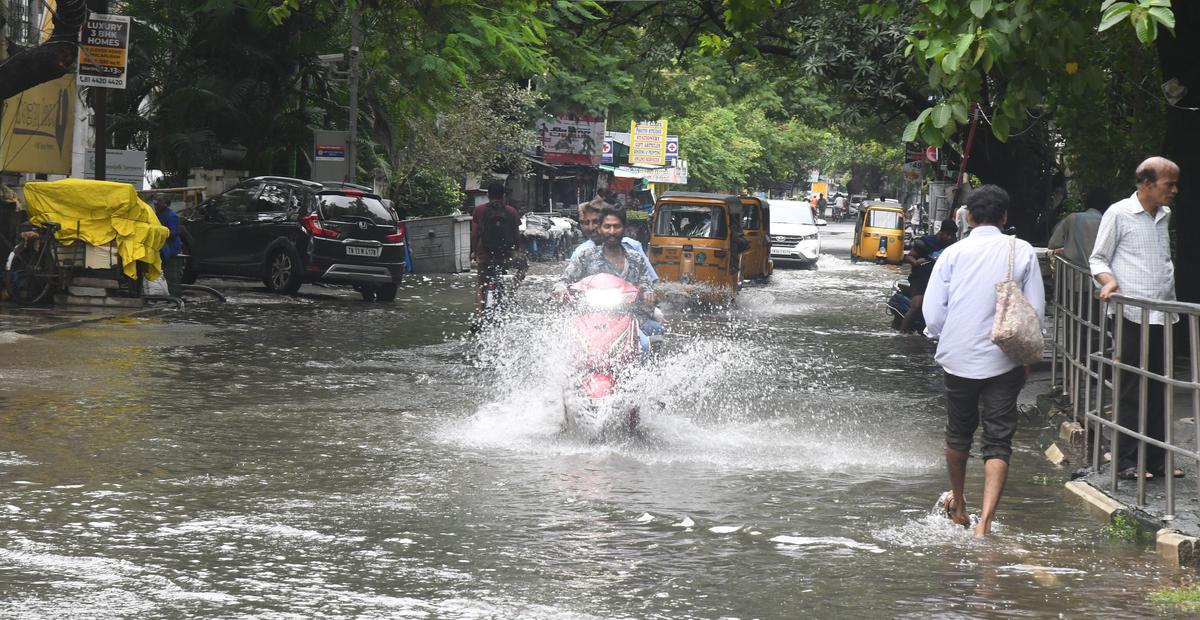 Motorists and pedestrians navigating an inundated Lloyds Road in Royapettah on Sunday.