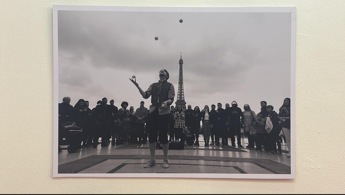 A juggler in action as people look on. Eiffel Tower is seen in the background. A juggler in action as people look on. Eiffel Tower is seen in the background.
