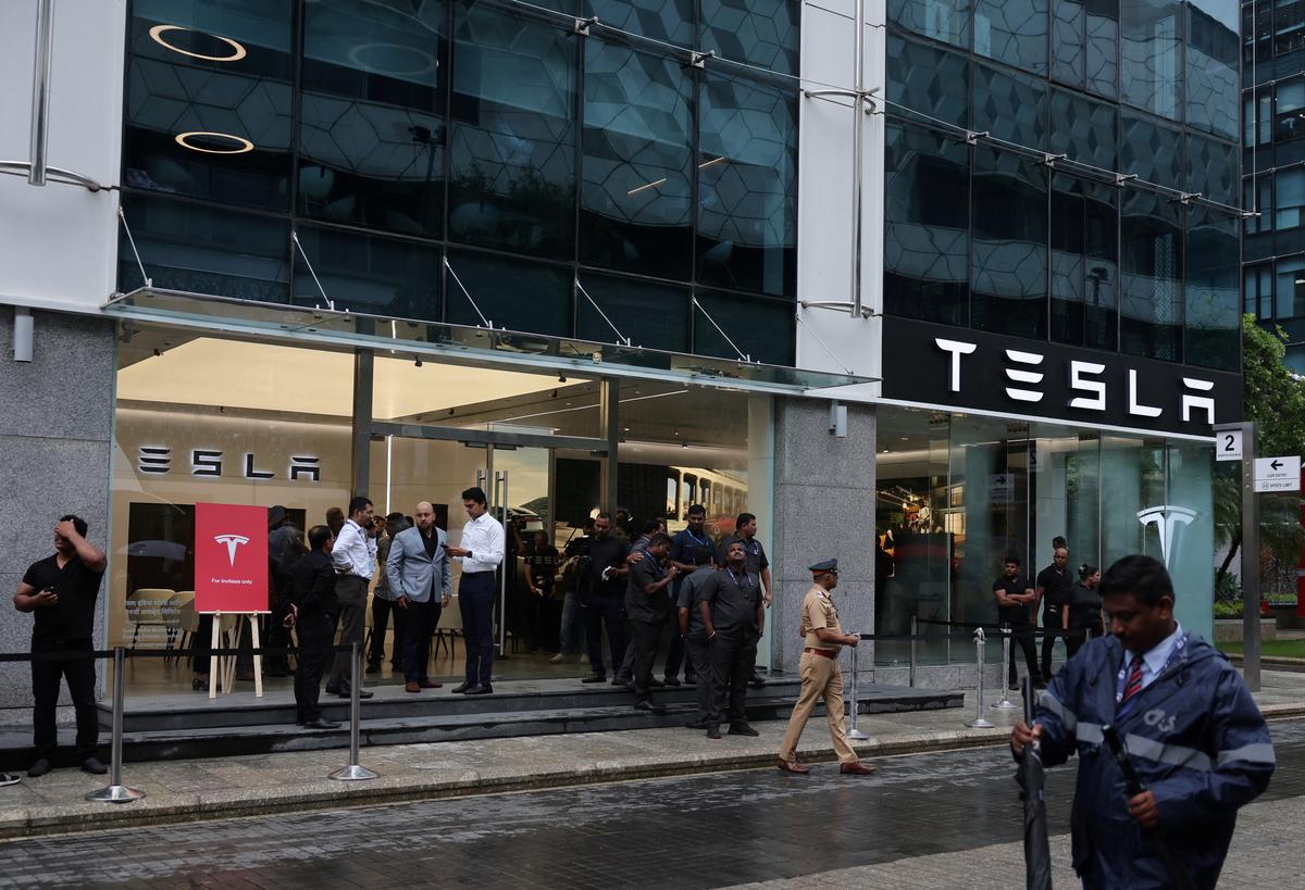 People are seen outside the Tesla showroom ahead of its opening in Mumbai on July 15, 2025.